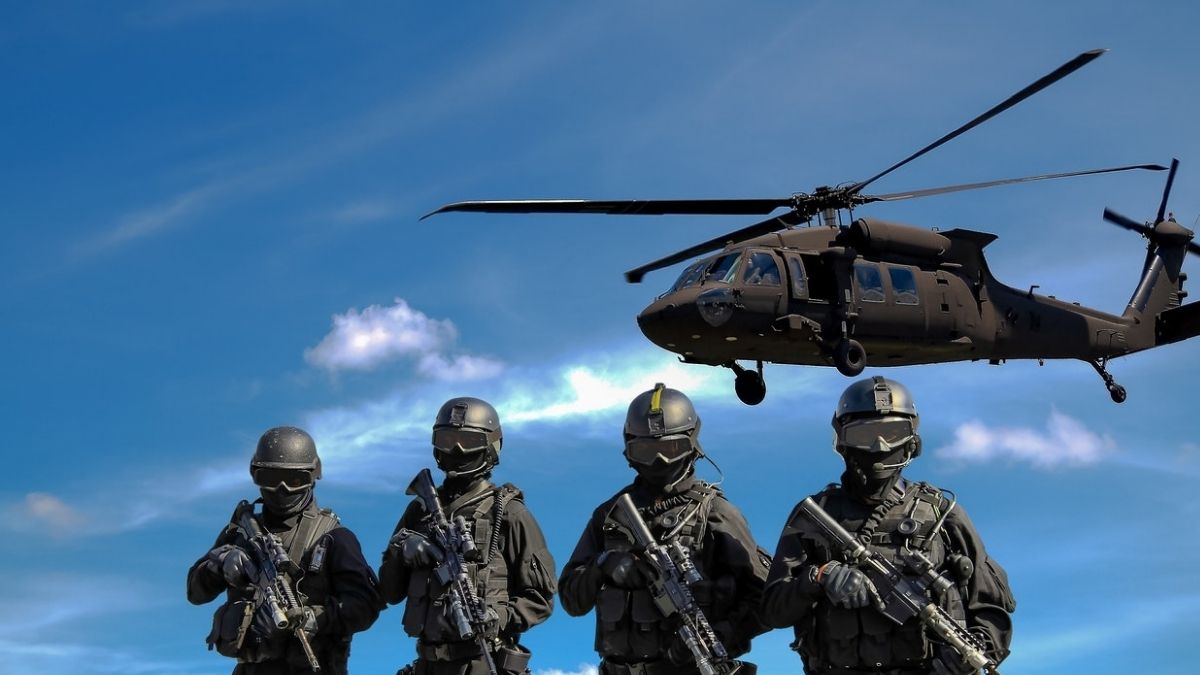 Four Soldiers Carrying Rifles Near Helicopter